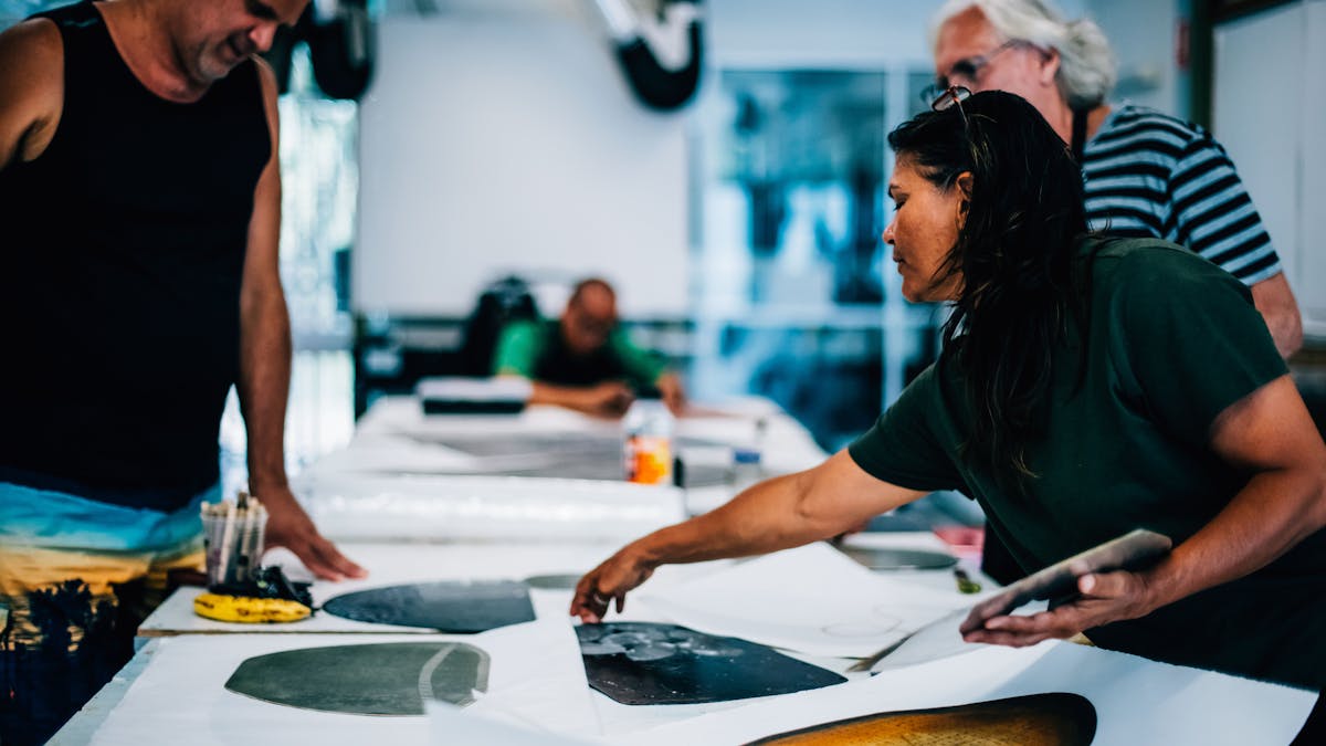 Aboriginal and Torres Strait Islander Artists look at prints and artworks in the studio and discuss