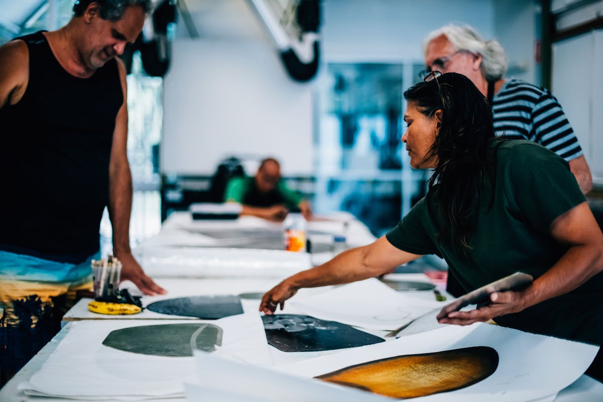 Aboriginal and Torres Strait Islander Artists look at prints and artworks in the studio and discuss