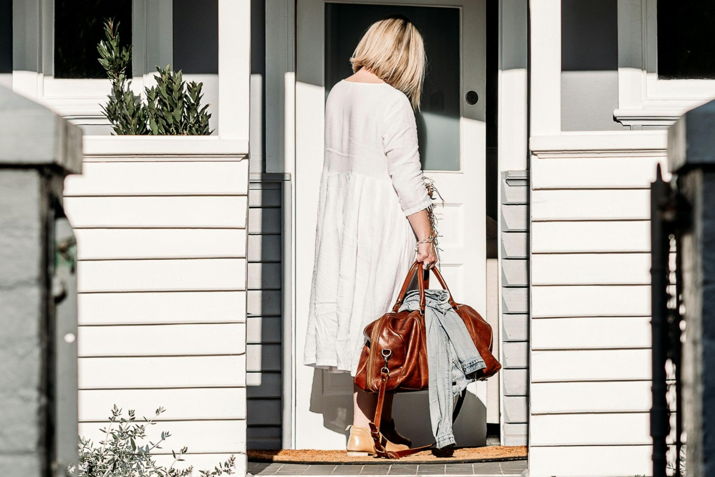 A guest carrying an overnight bag enters Hargans Cottage in Carcoar.