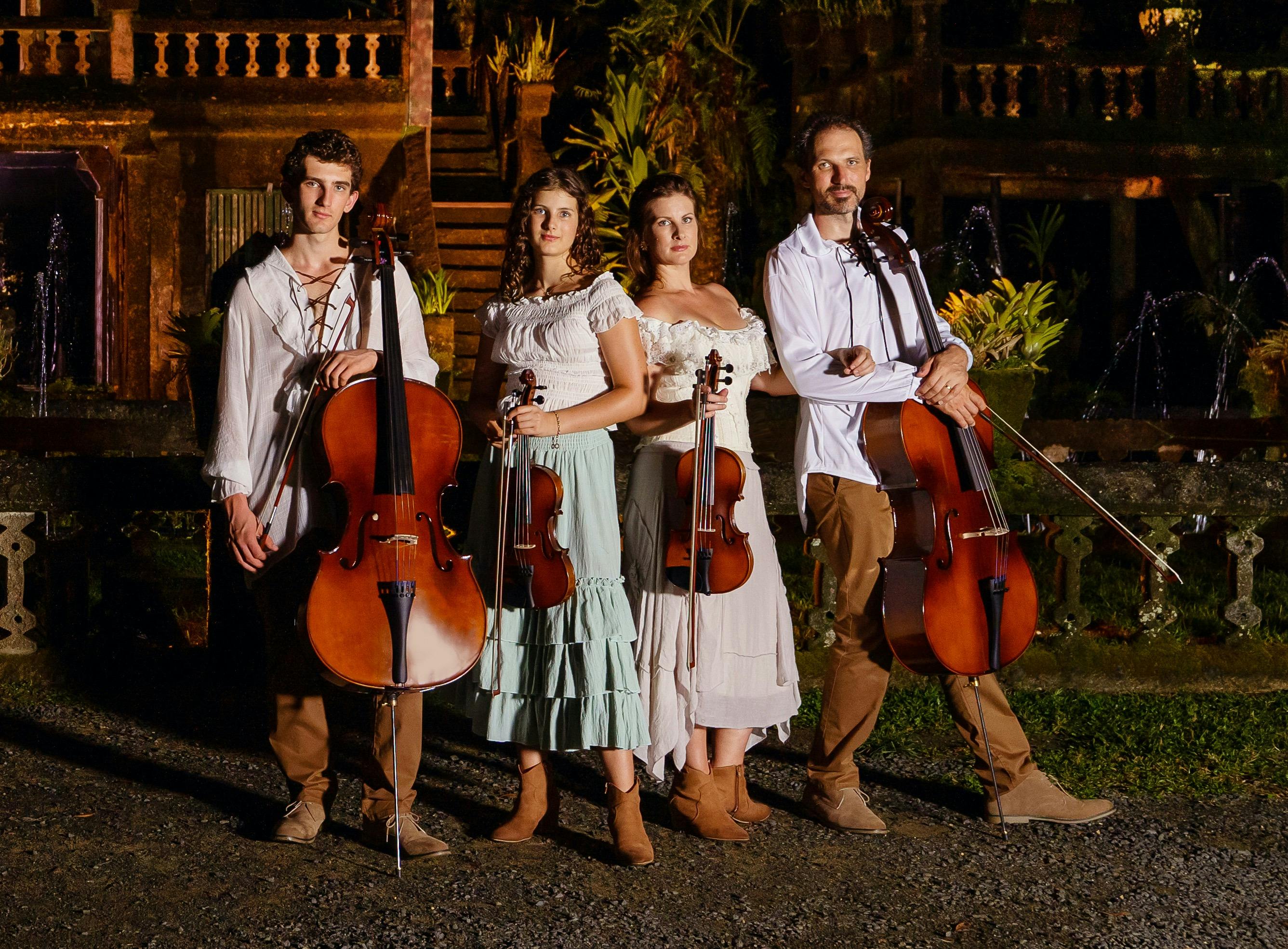 Four members of the String Family band dressed in Celtic costumes, each holding Cellos & violins