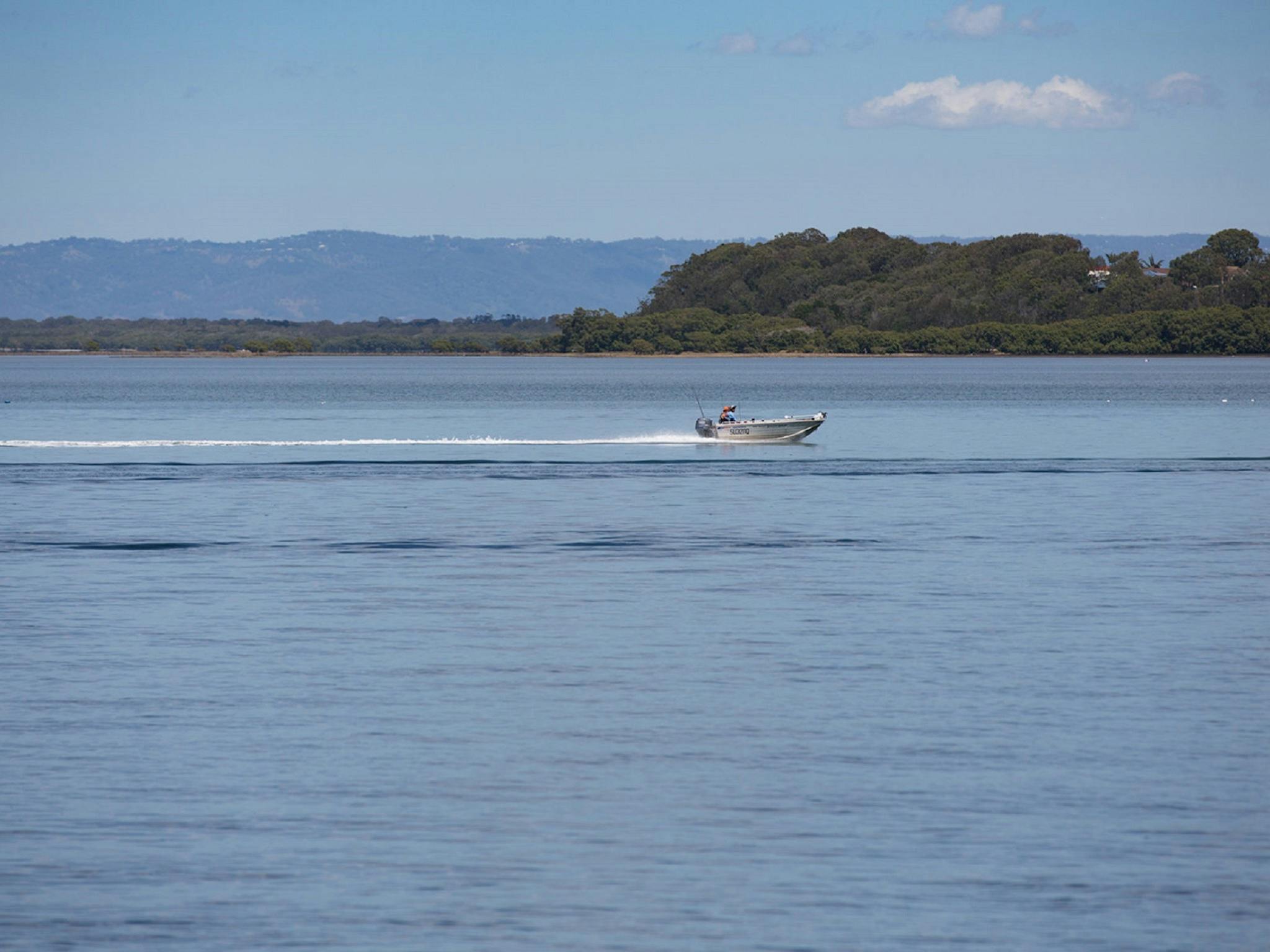 Tinny gliding gliding over the water in Pumicestone Passage Tinny gliding gliding over the water in Pumicestone Passage