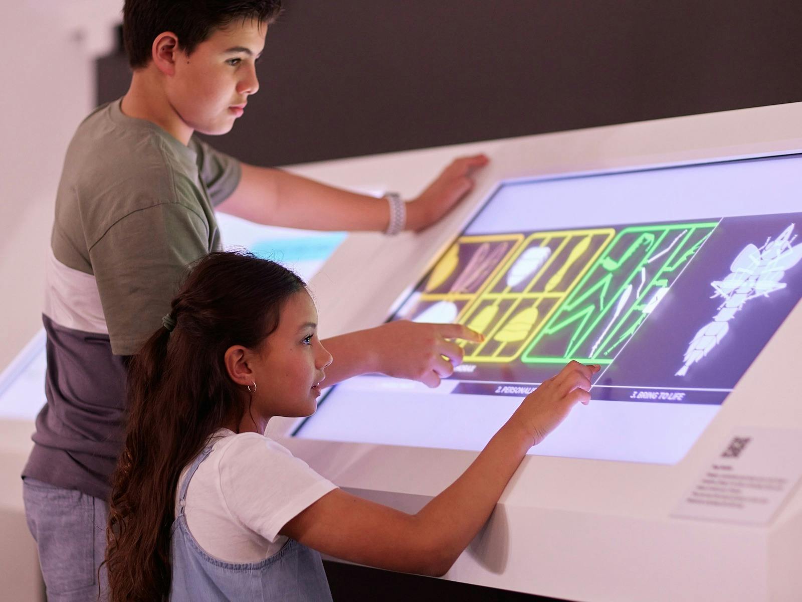 Two children engaging with interactive museum exhibition