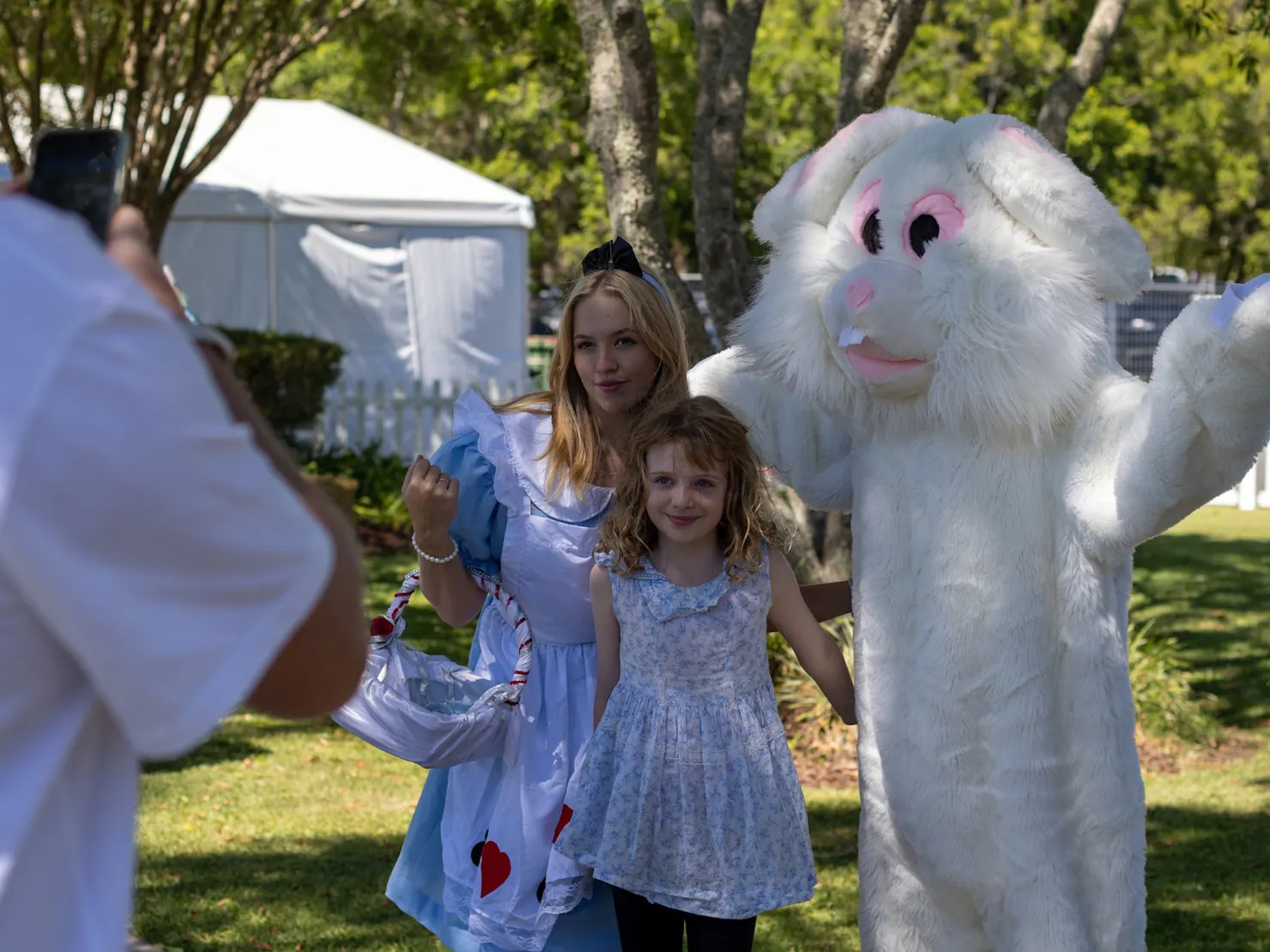 Easter Bunny and Alice in Wonderland taking a photo with a little girl