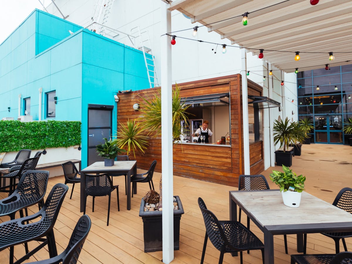 Outdoor bar with cafe style table and chairs, bar opening to alfresco area,