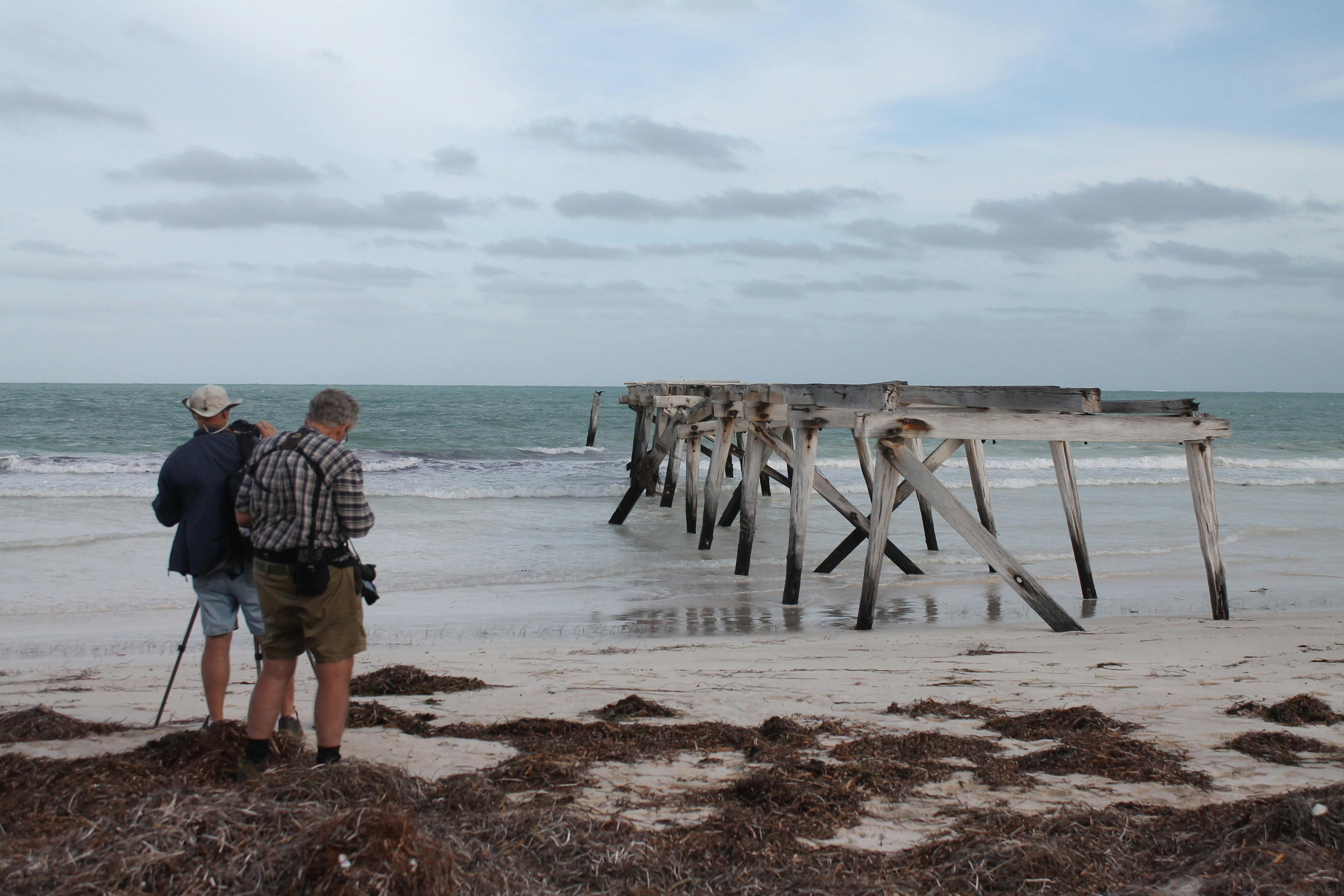 Couple of men setting up photos at  Eucla jetty