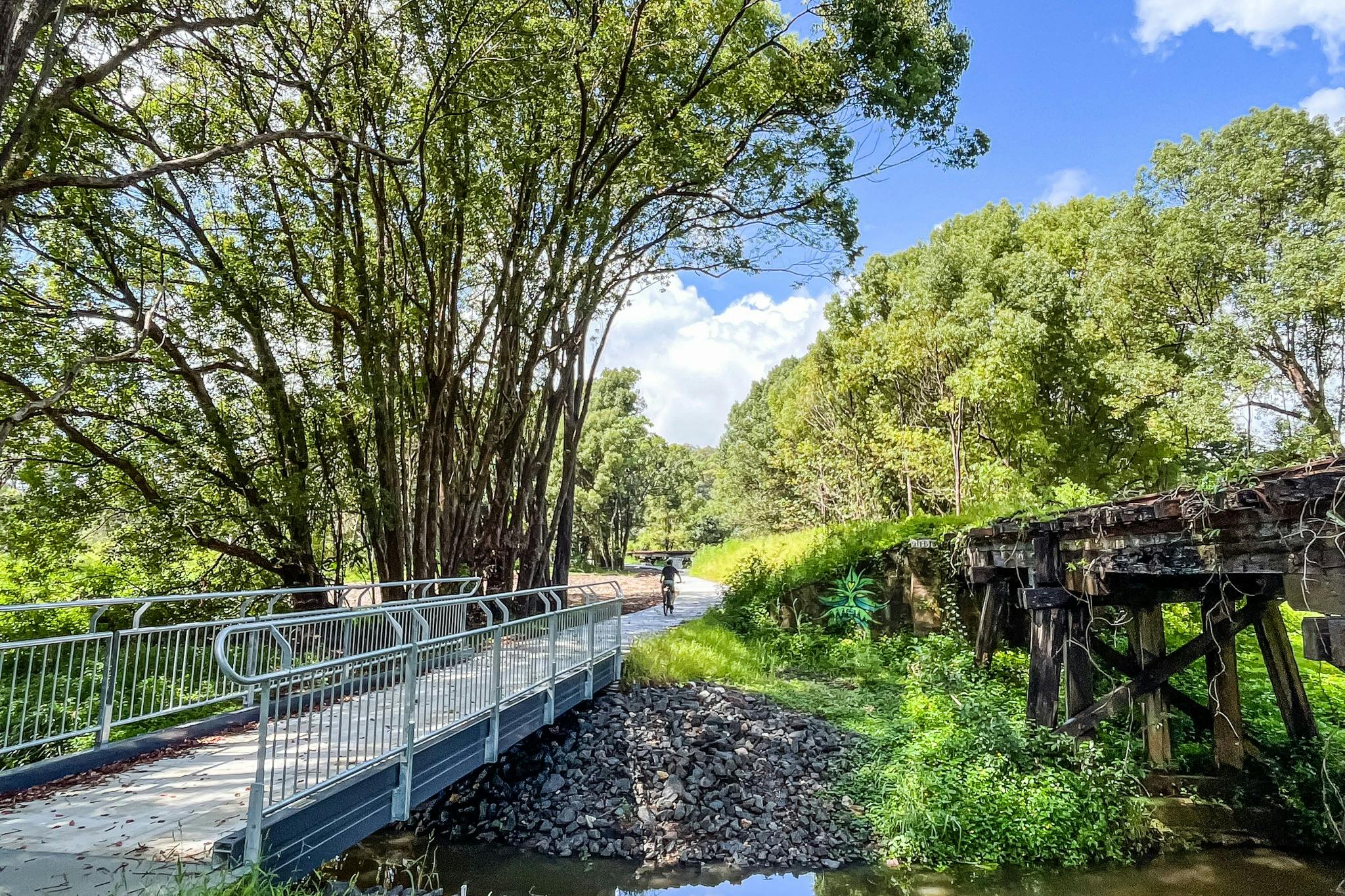 Section of trail showing a new bridge next to an old timber bridge section of the rail trail