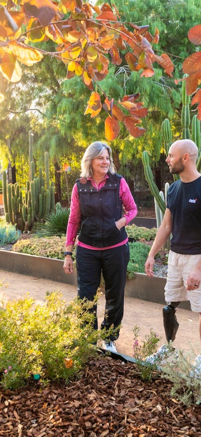 Two people in a garden with autumn leaves and cacti