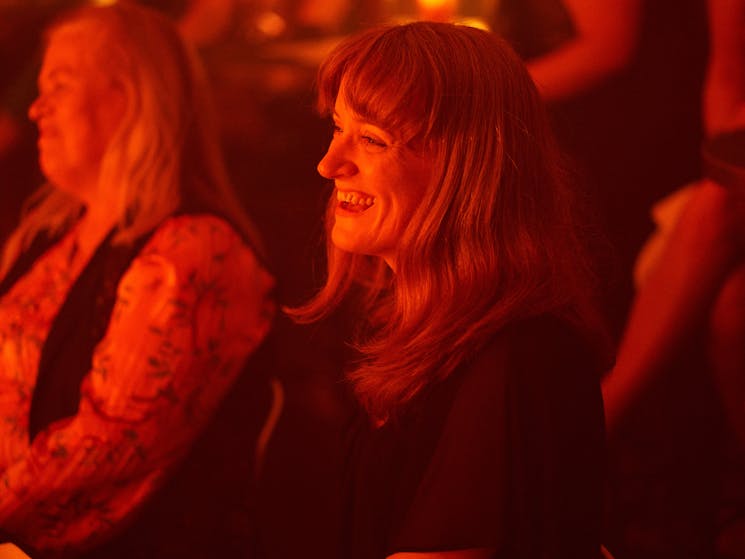 Sydney woman in audience of dinner theatre smiling
