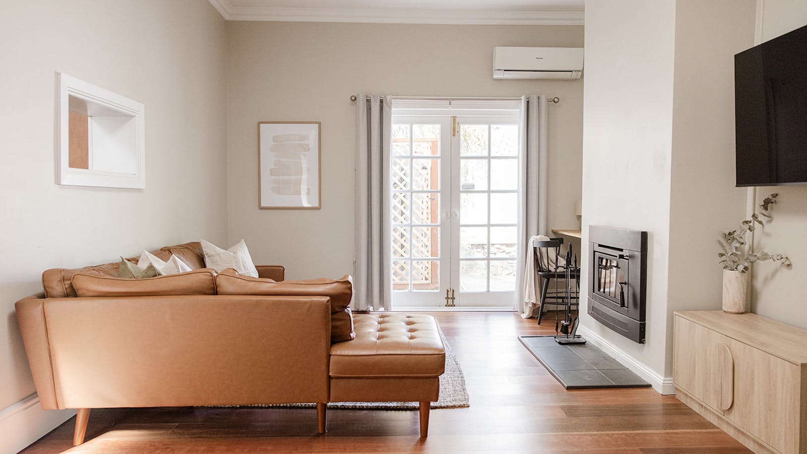 Spacious lounge room with a wood fire place over looking our private courtyard