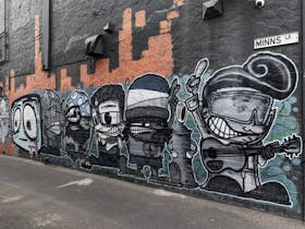 little cartoon artworks of people on brick wall