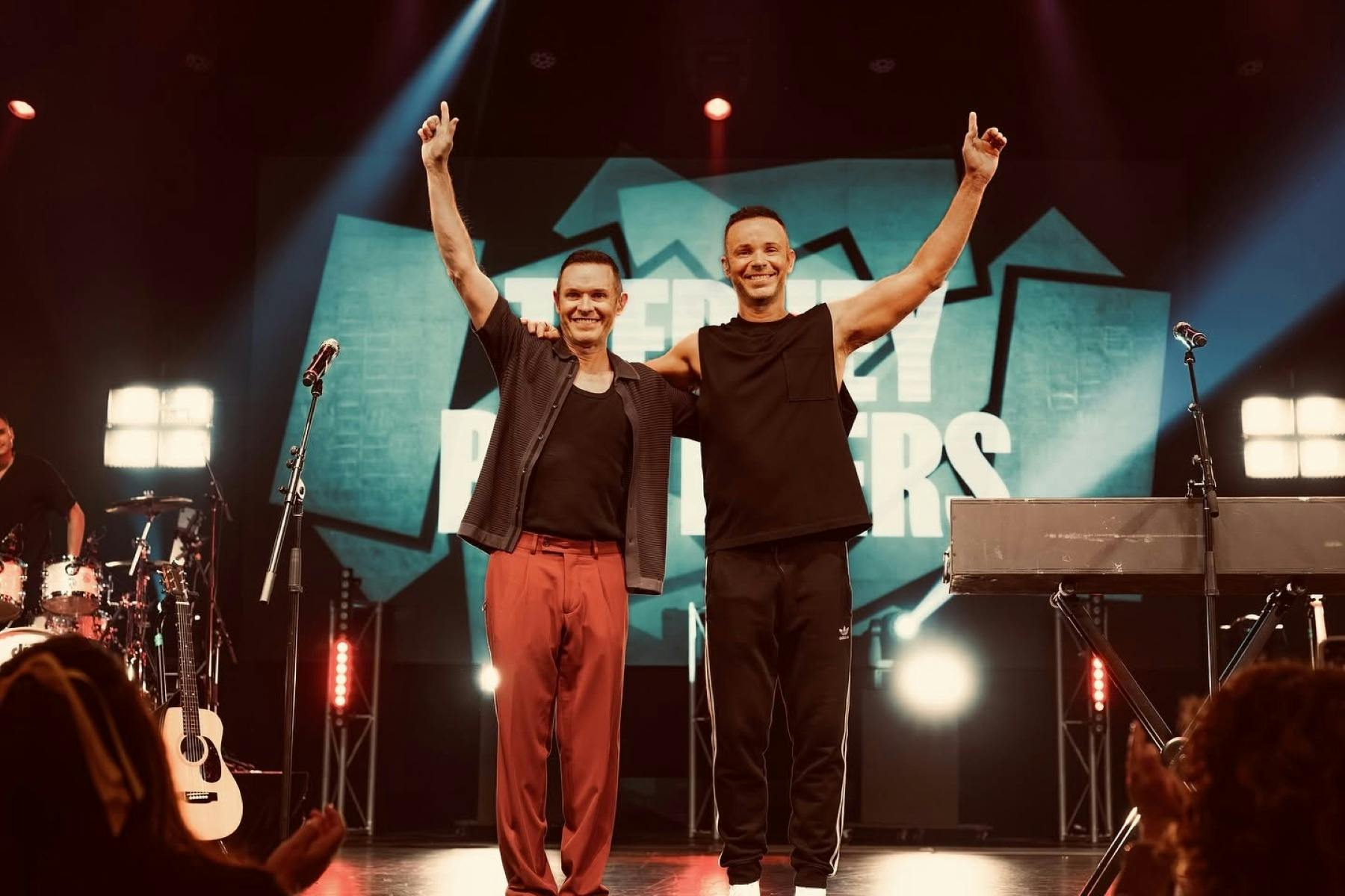 Two Men on Stage Waving