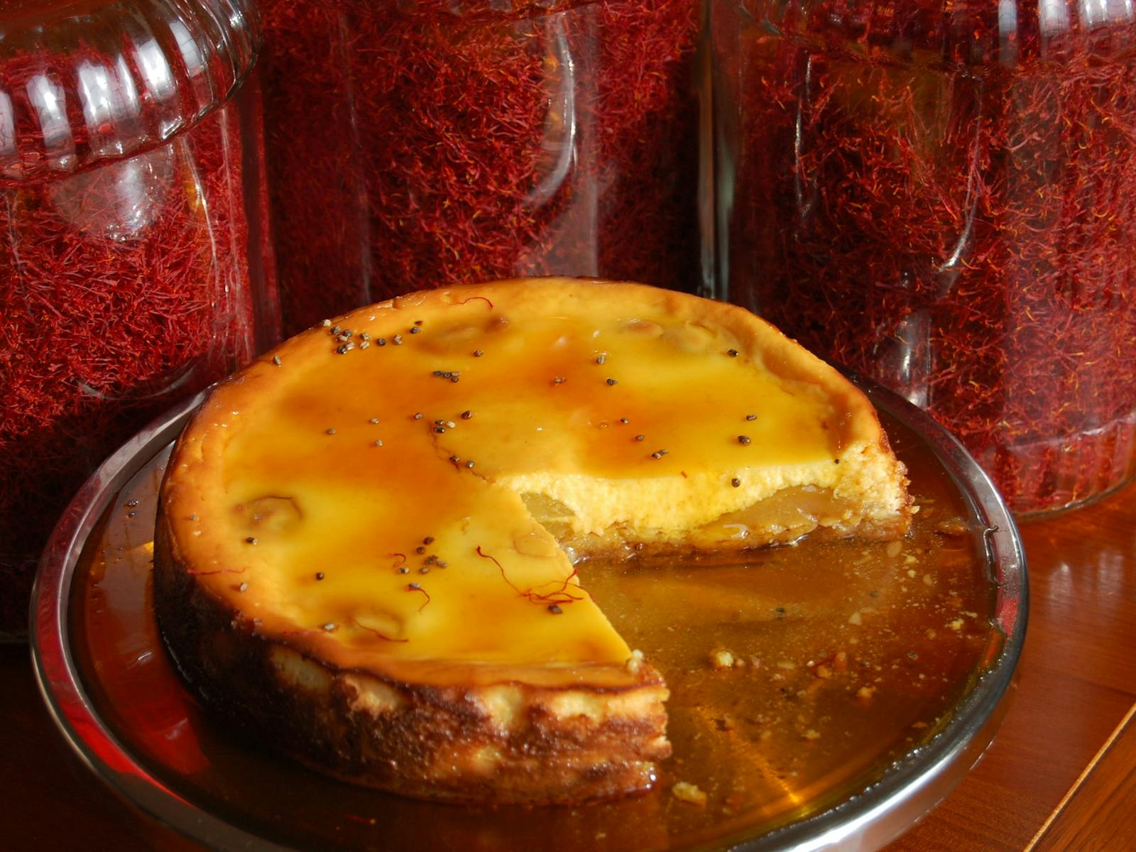 Saffron poached pear cheesecake drizzled with a saffron syrup and large jars of saffron