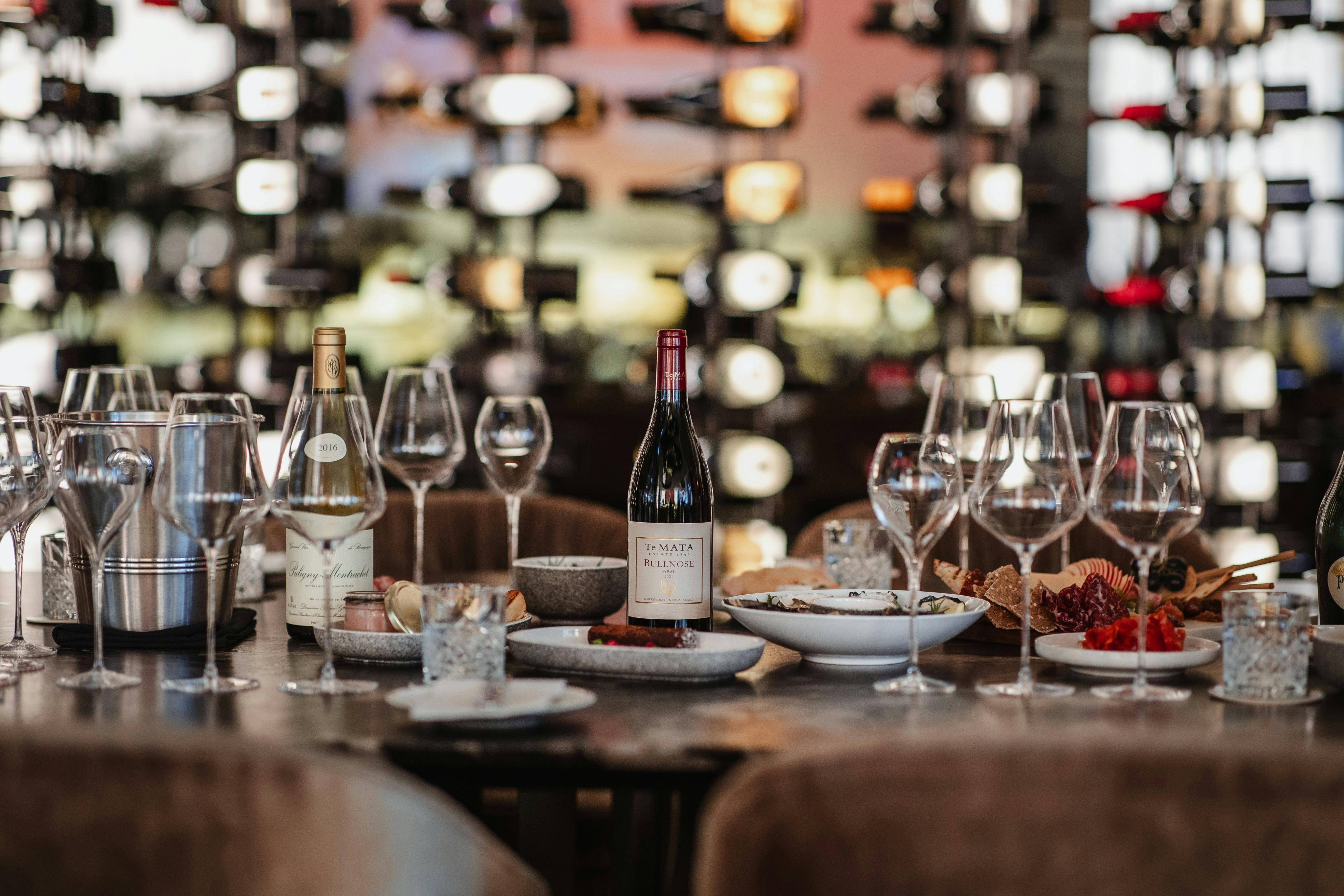 Wine, wine glasses and charcuterie board on marble table in The Reserve Wine Bar
