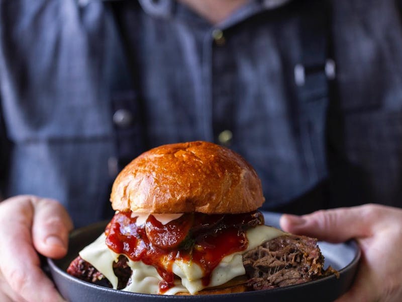 A man holding a gourmet burger