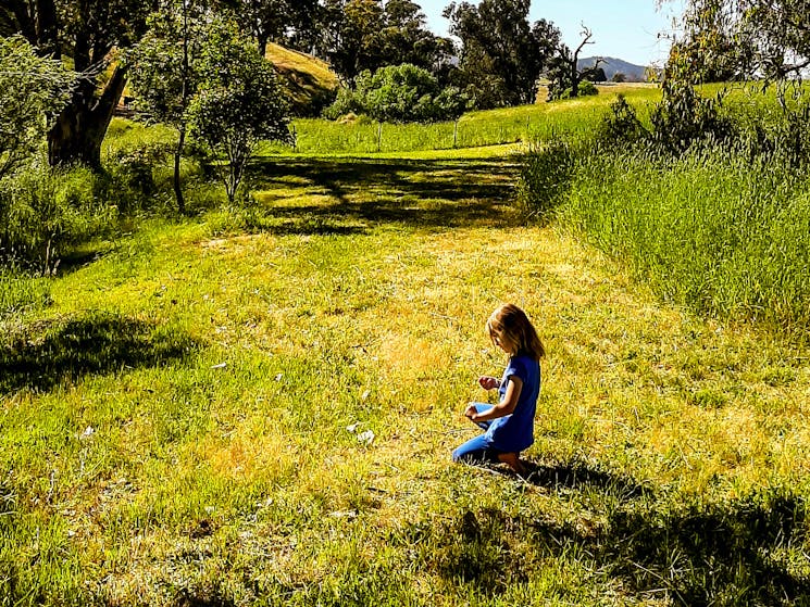 Girl sitting in grass on campsite. Peaceful experience.