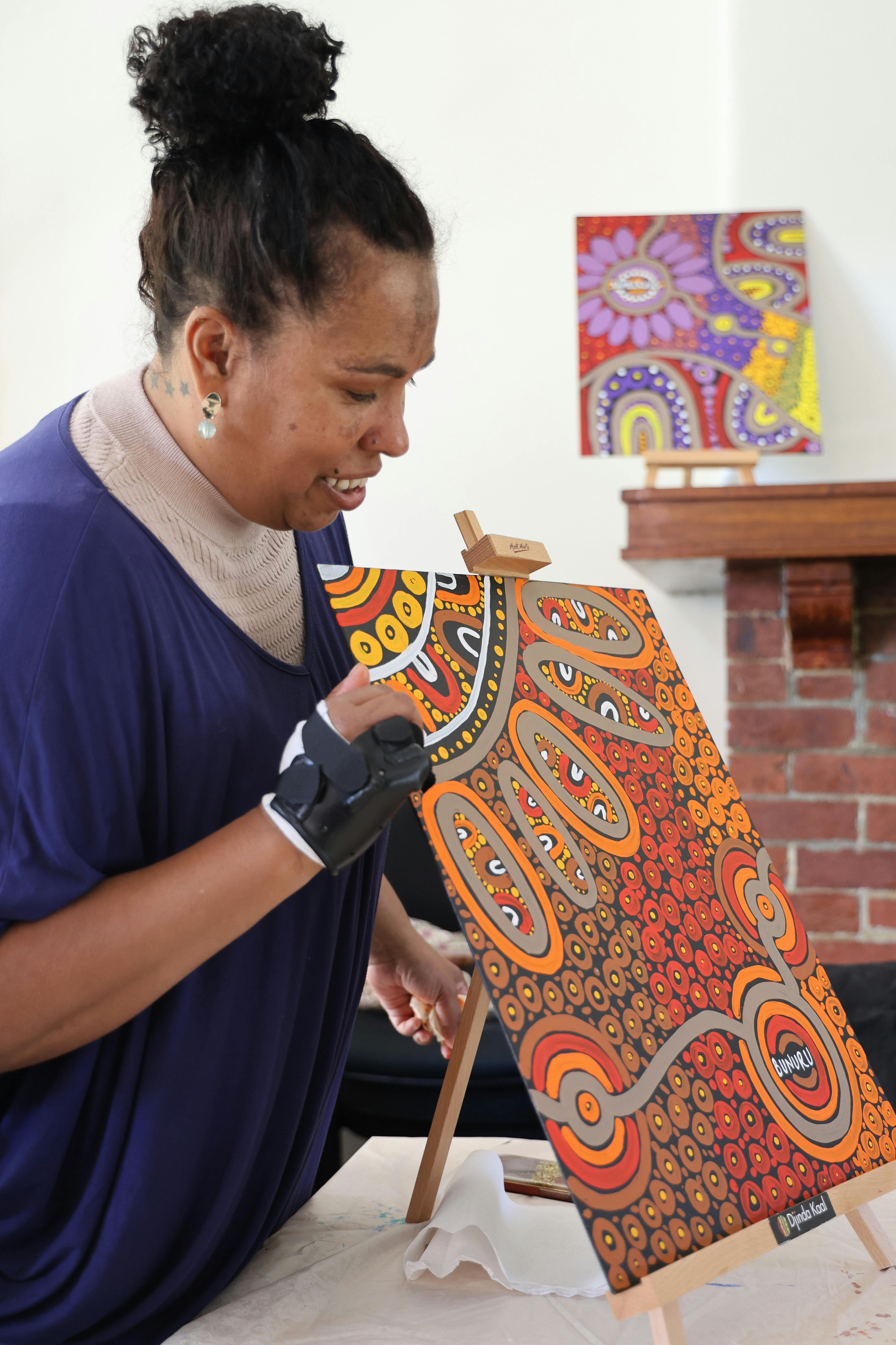 Fiona Reidy holding their aboriginal artwork