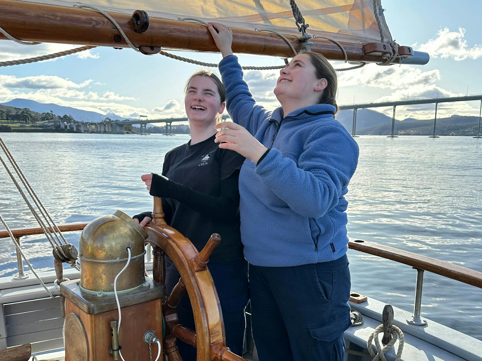 Two of the crew at the helm steering away from the Tasman Bridge
