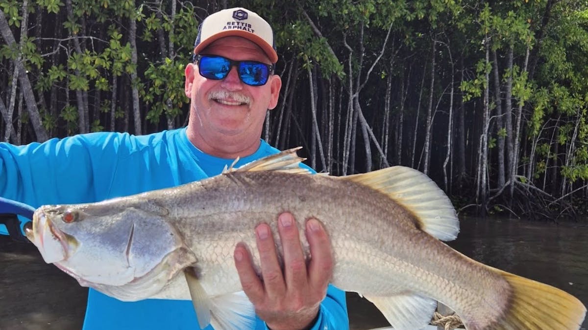 Man holding a barramundi - catch of the day with Gone Fishing Cairns