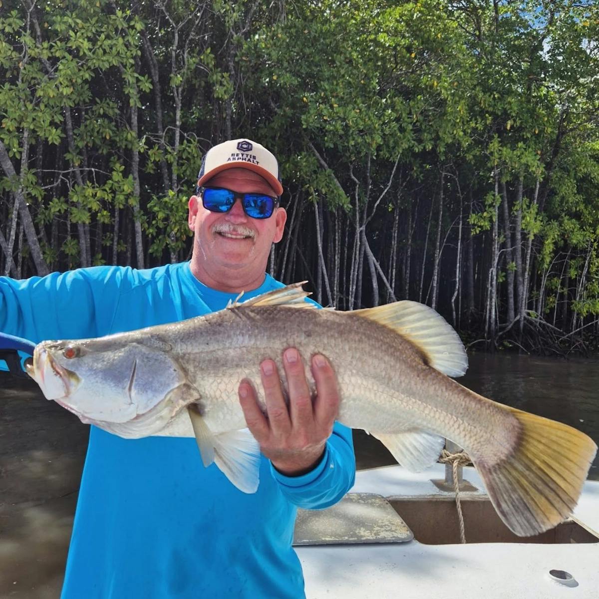 Man holding a barramundi - catch of the day with Gone Fishing Cairns