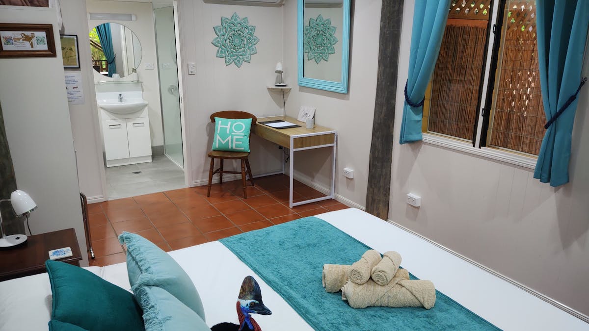 General picture of the King Room showing the bed, writing desk and en suite bathroom entrance
