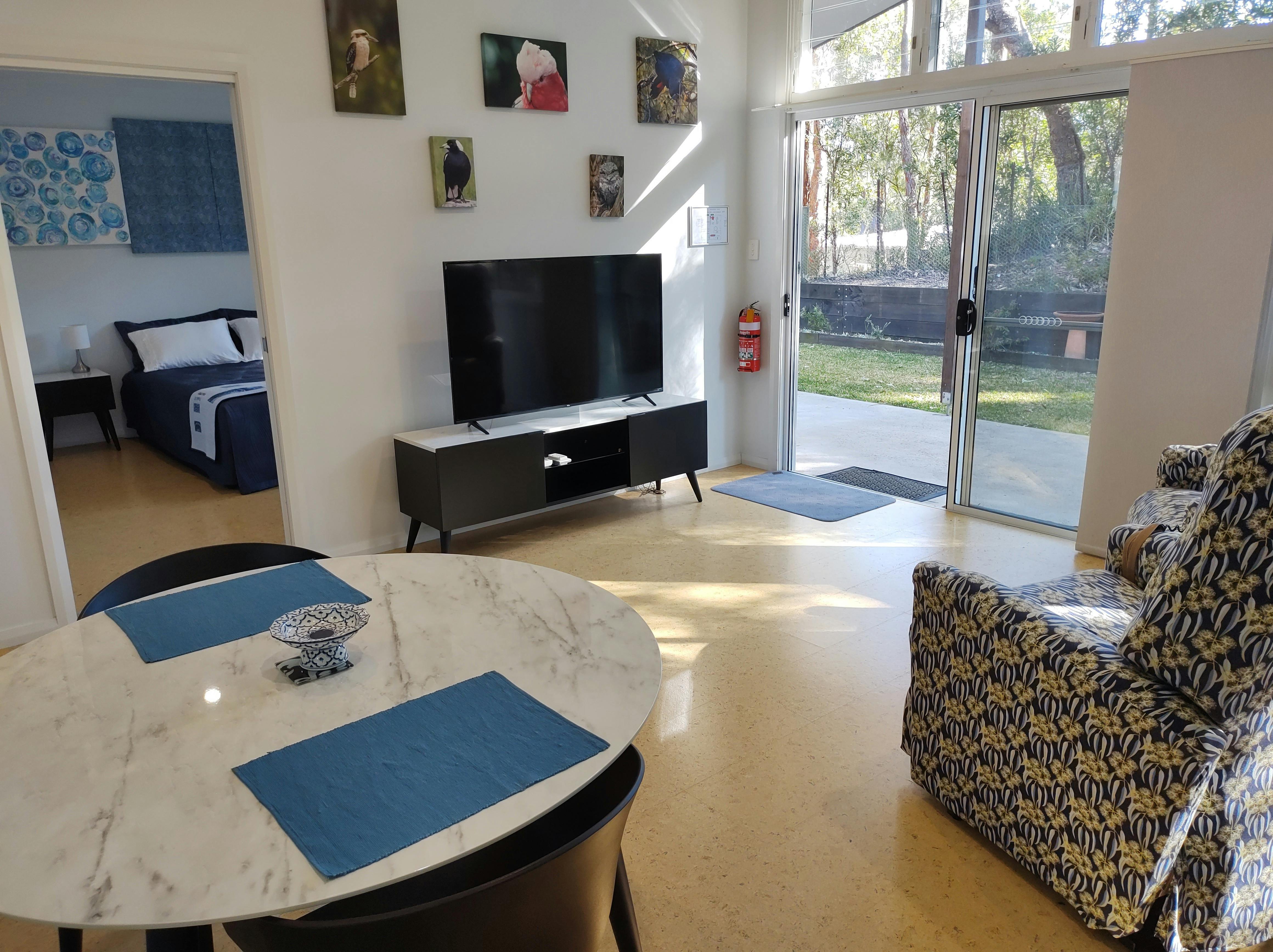 Bright, airy open plan living area with air-conditioning and a large screen TV