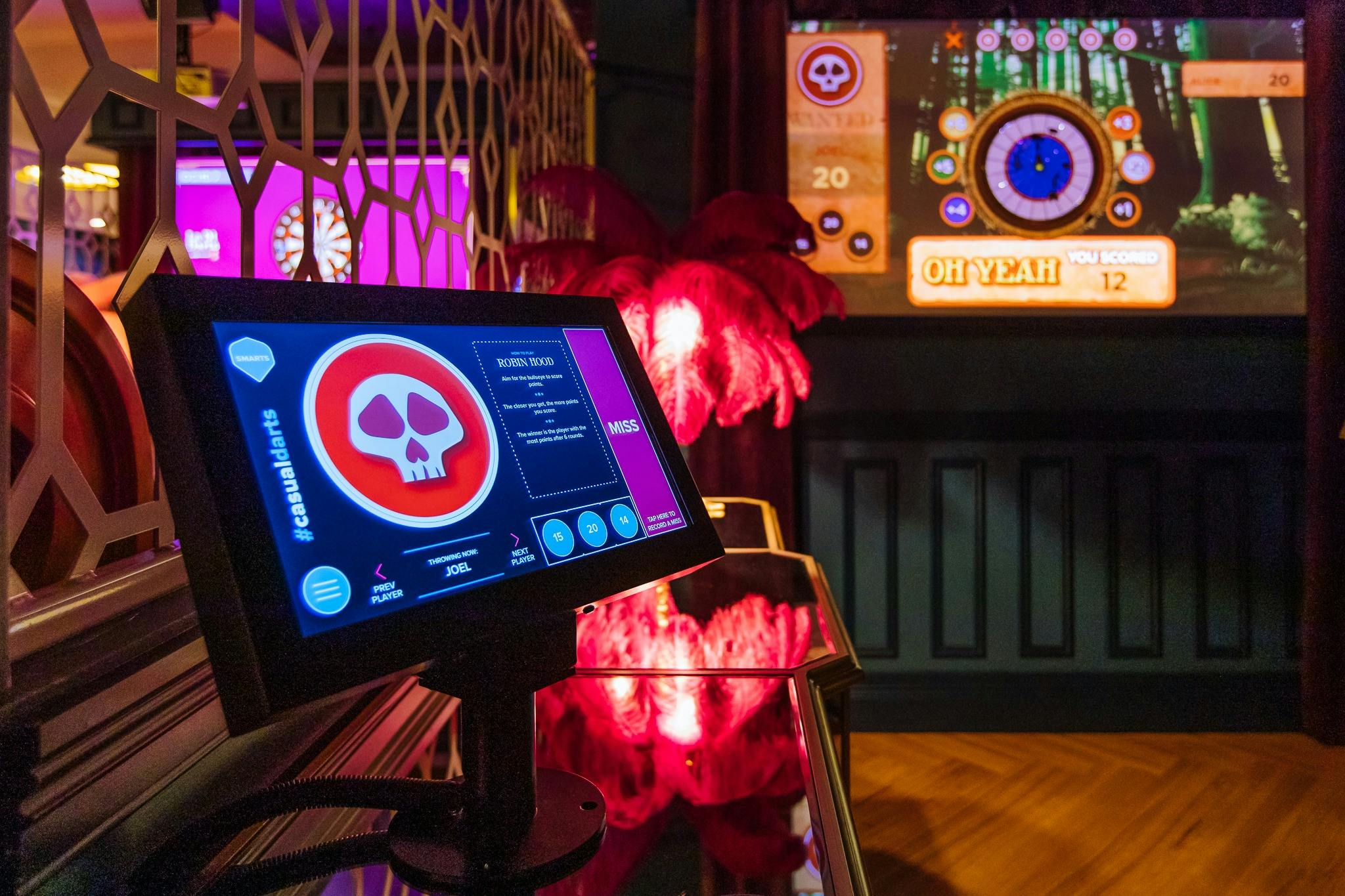 화면에 해골이 있는 La Di Darts 게임이 표시됩니다. 백그라운드에서 다트 보드를 볼 수 있습니다.