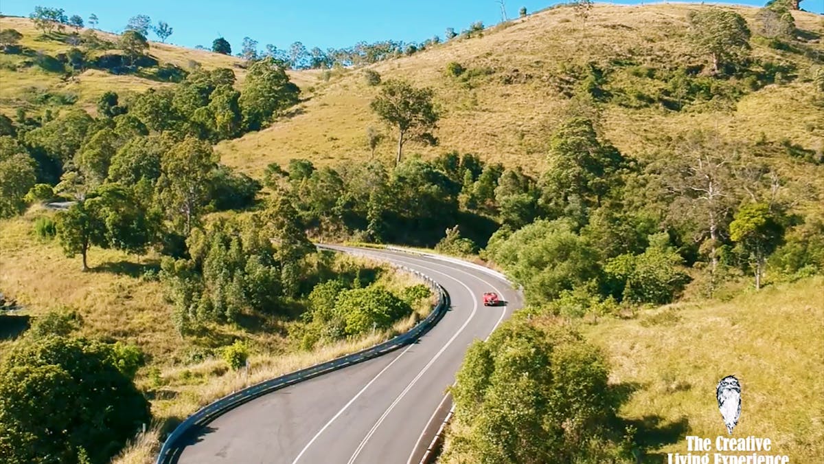red car driving windy country road red car driving windy country road