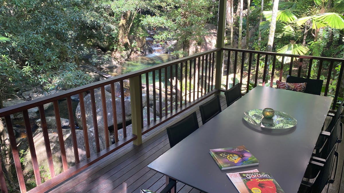 Outdoor dining with waterfall view at Daintree Secrets