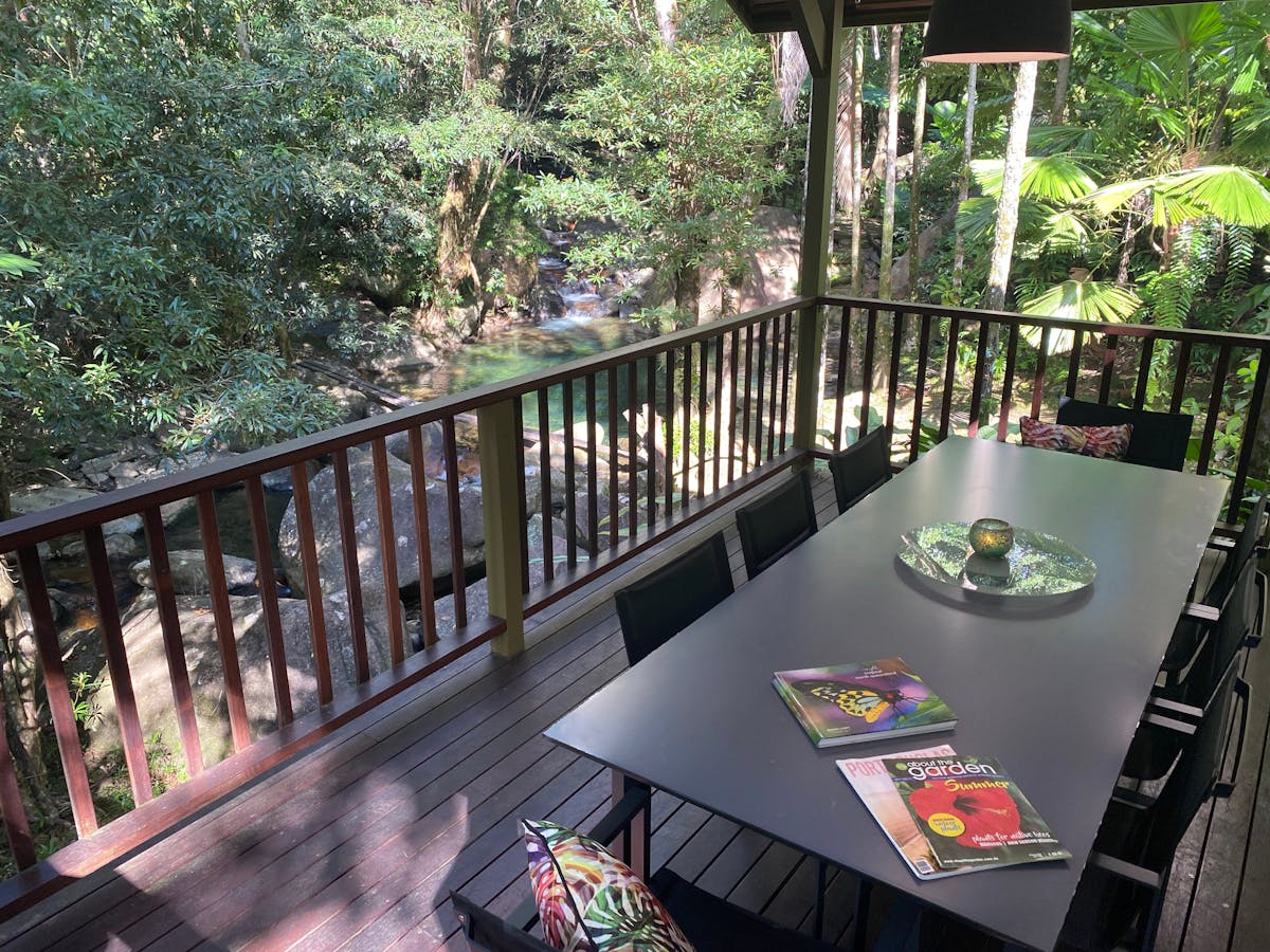 Outdoor dining with waterfall view at Daintree Secrets