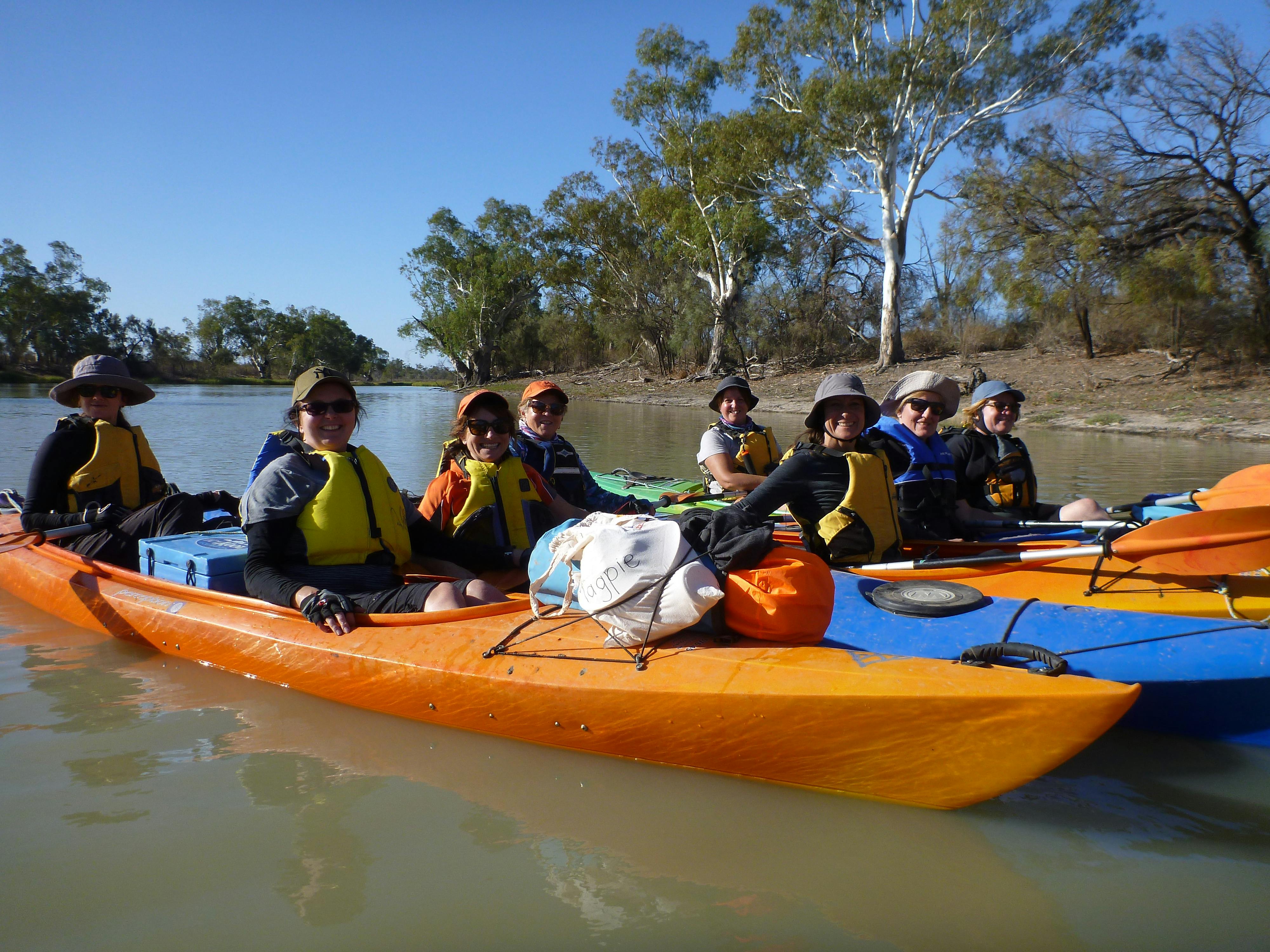 A group of ladies in double kayaks, loaded with camping gear