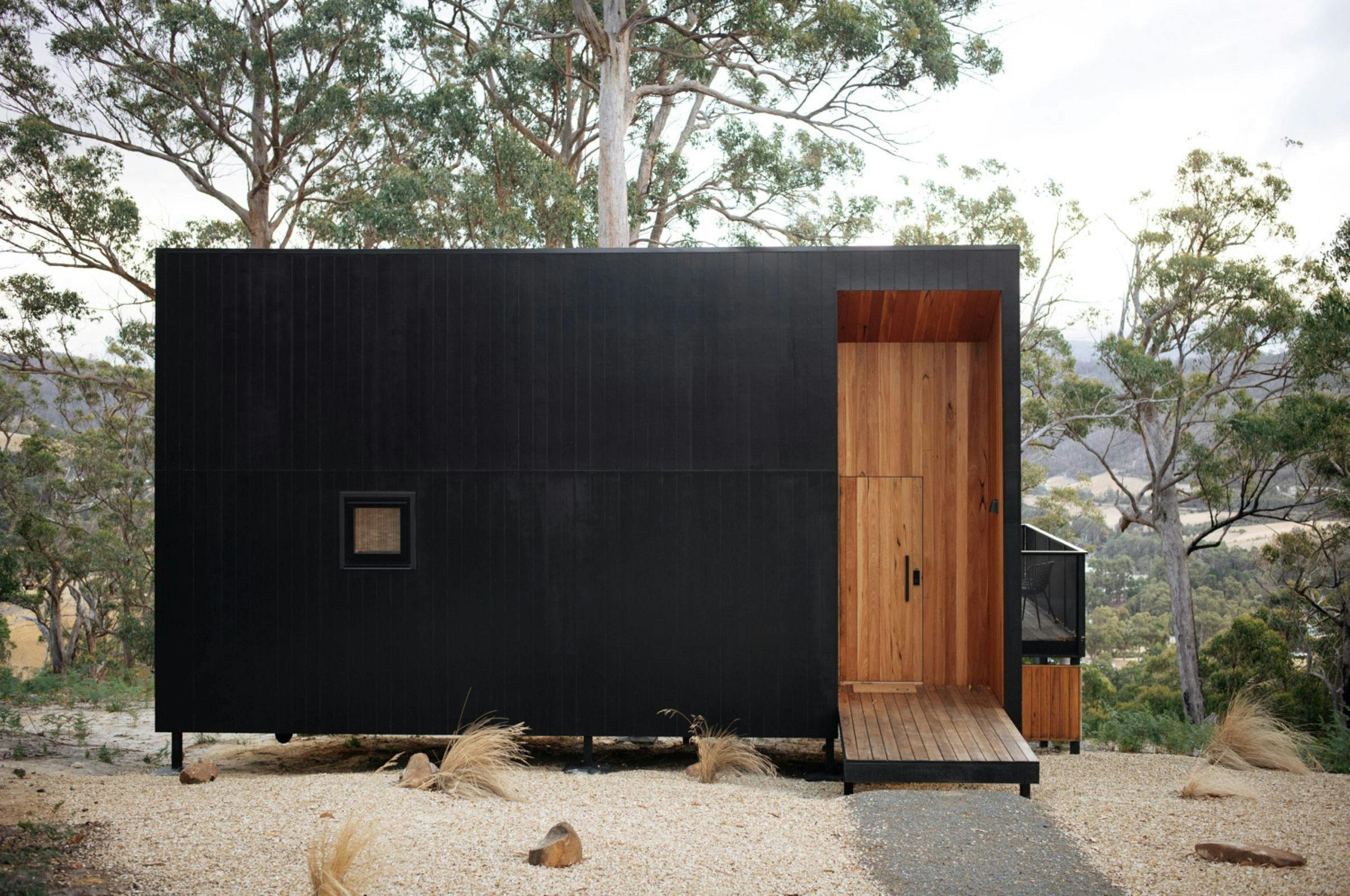 Minimalist exterior facade of Hunter Huon Valley with timber entry, design by Maguire & Devine