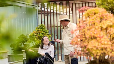 Volunteer guide talking with visitor in a wheelchair