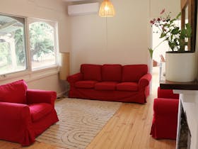 Smaller living room with 1 x 3 seater and 2 x 1 seaters