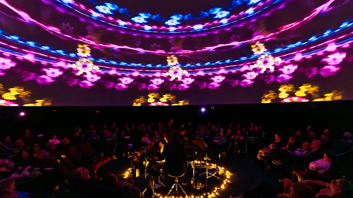 2025 show. A wide shot featuring the band, audience and a kaleidoscope visual overhead
