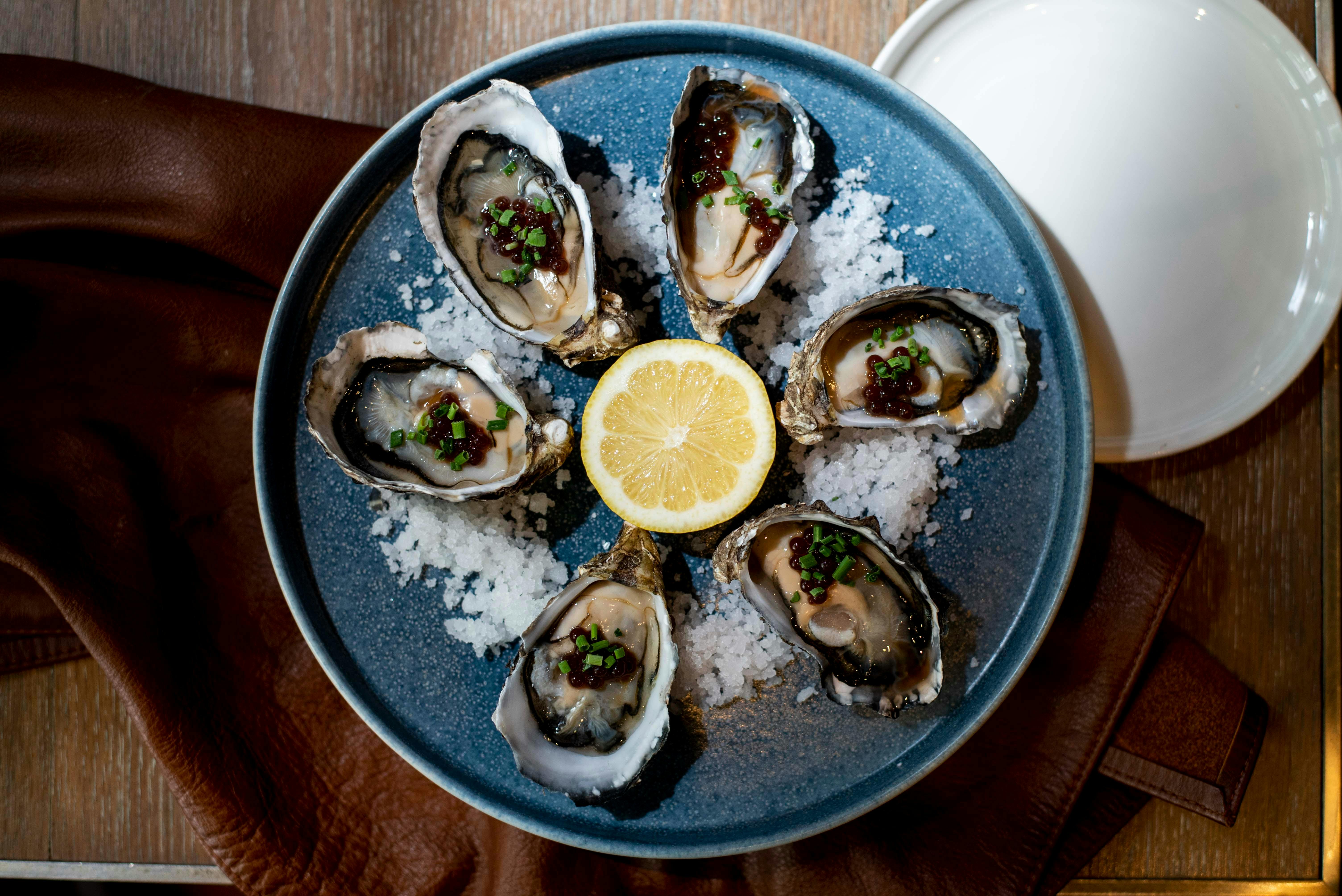 A plate of oysters served with caviar and lemon