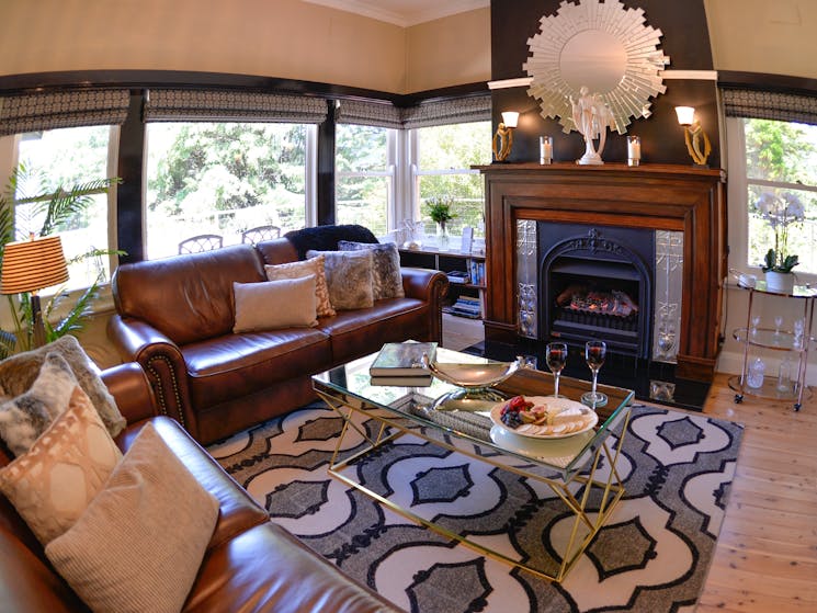 Plush leather lounge room with gas-log fireplace and views across the Jamison Valley