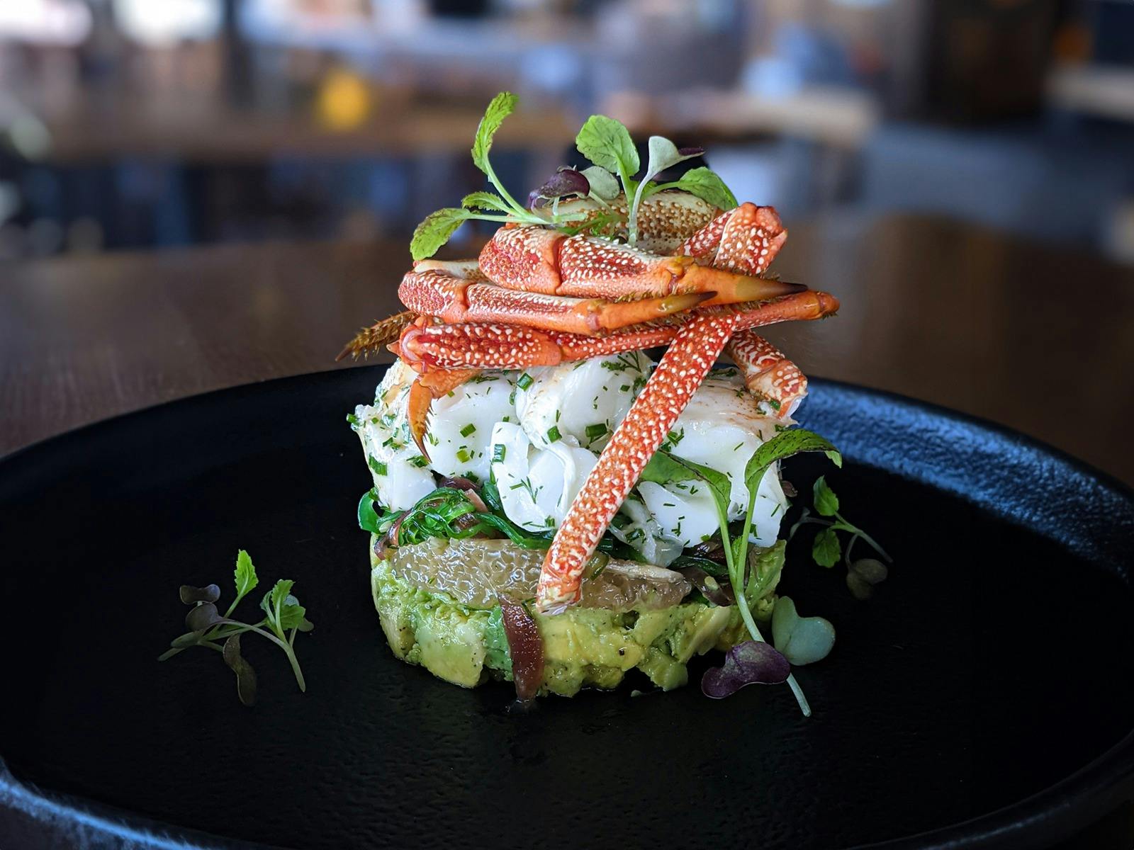 A dish with Rock Lobster meat and legs, arrange on a grapefruit and avocado base