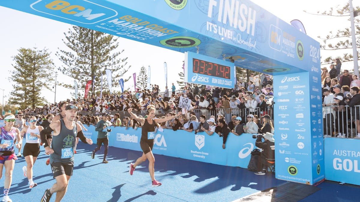 Happy Gold Coast Marathon finishers showing off their medals