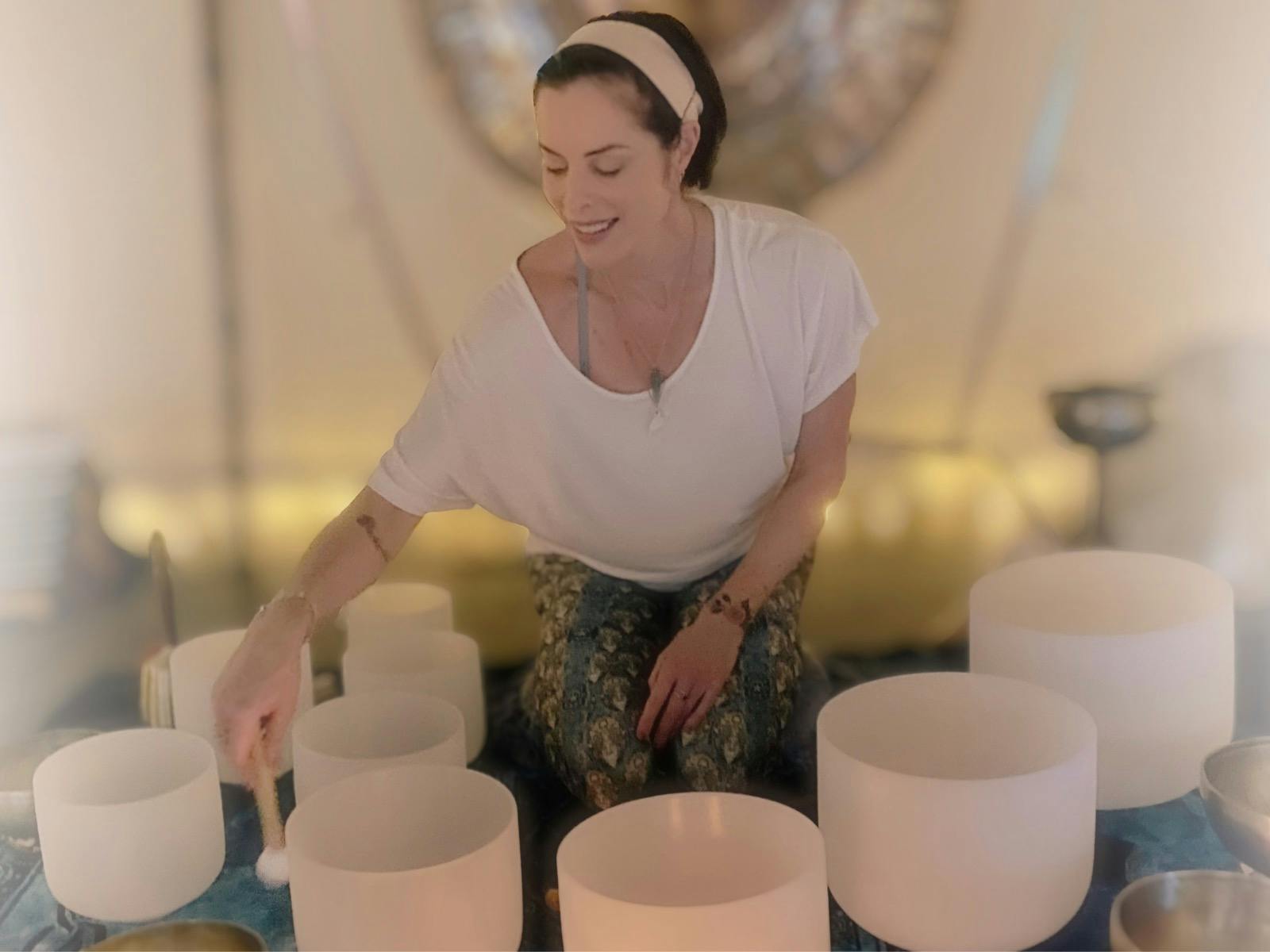 Natalie playing crystal singing bowls. Gong in background.