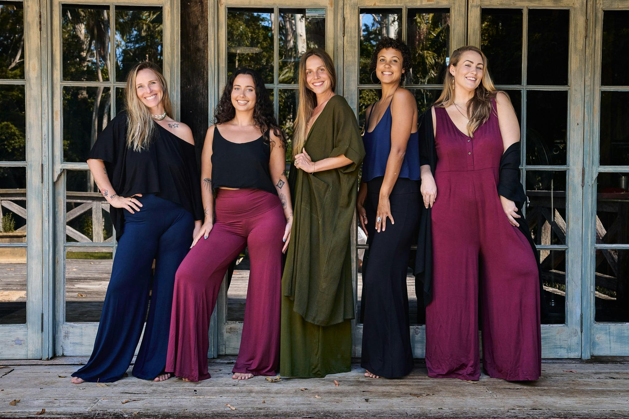 A group of women wearing clothing in front of window doors
