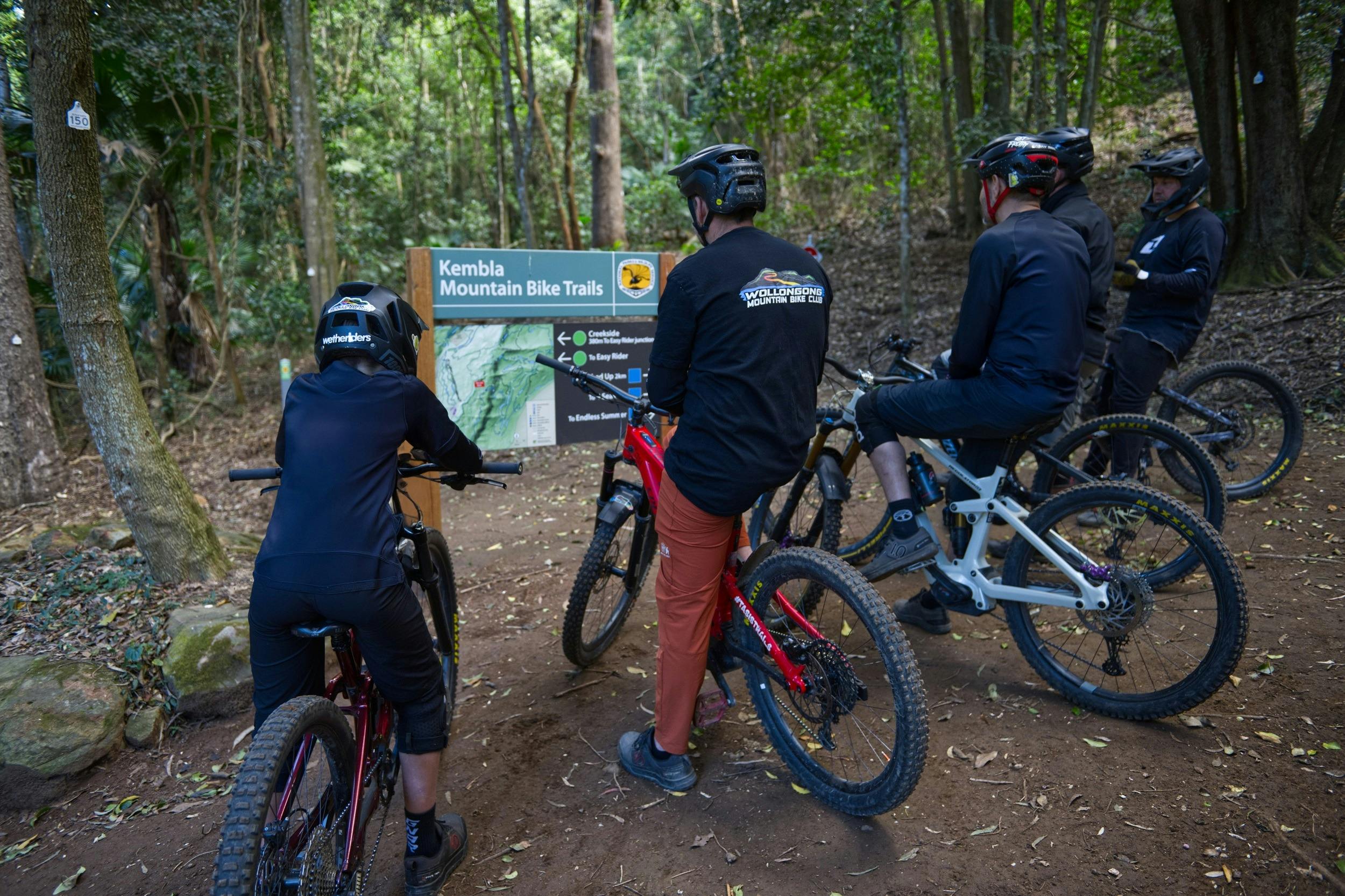 A group of cyclists stop to check the map on Kembla mountain bike trails.