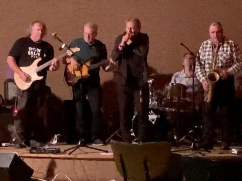 5 men on stage playing and singing