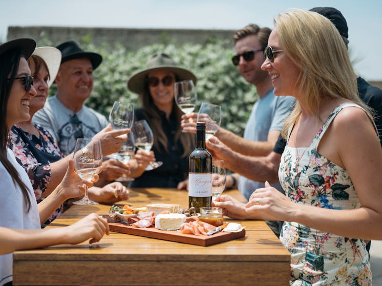 A group tasting wines in the courtyard around a table