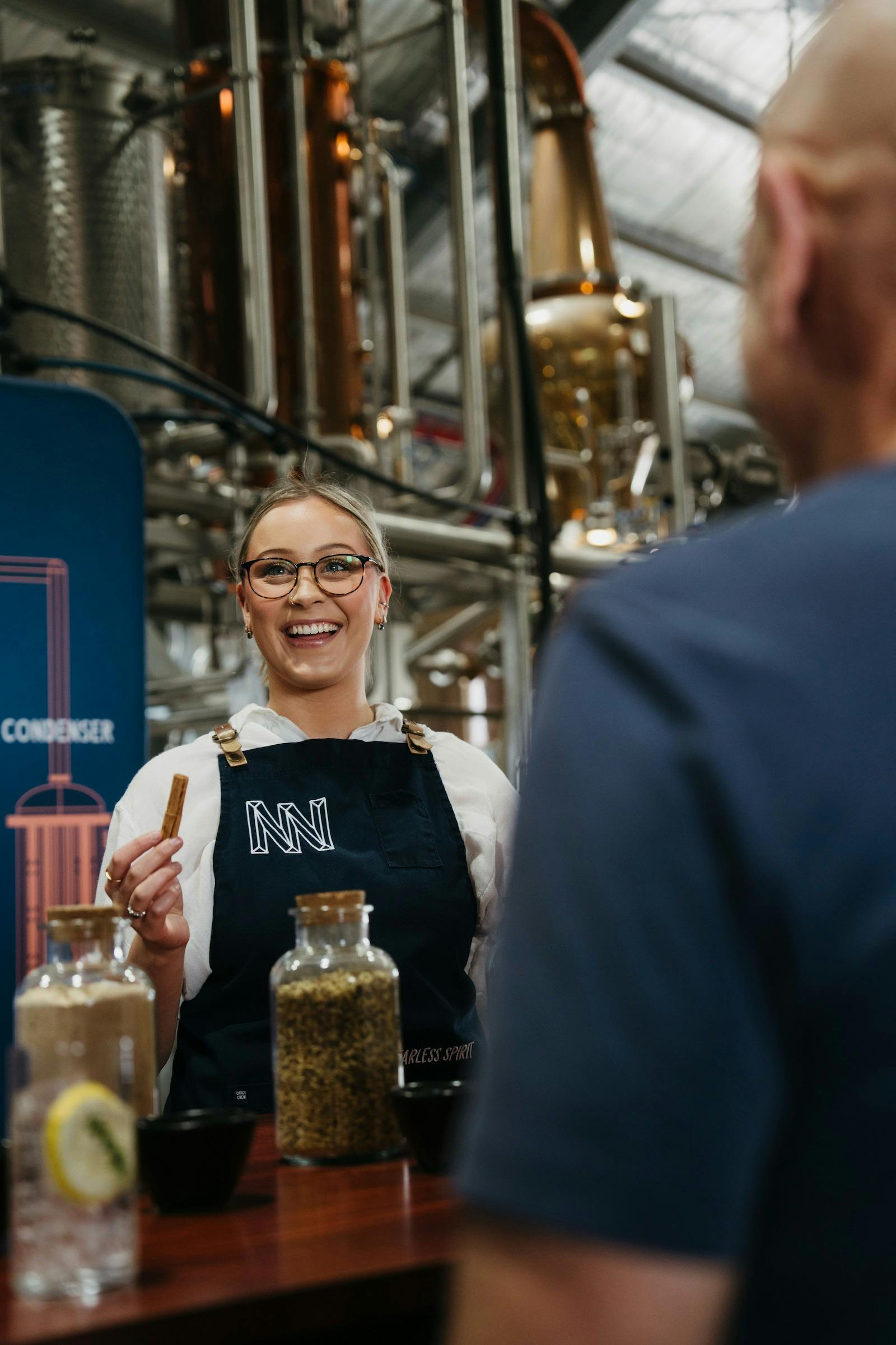 Gin expert holding some cinnamon as they explain the botanicals of the gin, still in the background