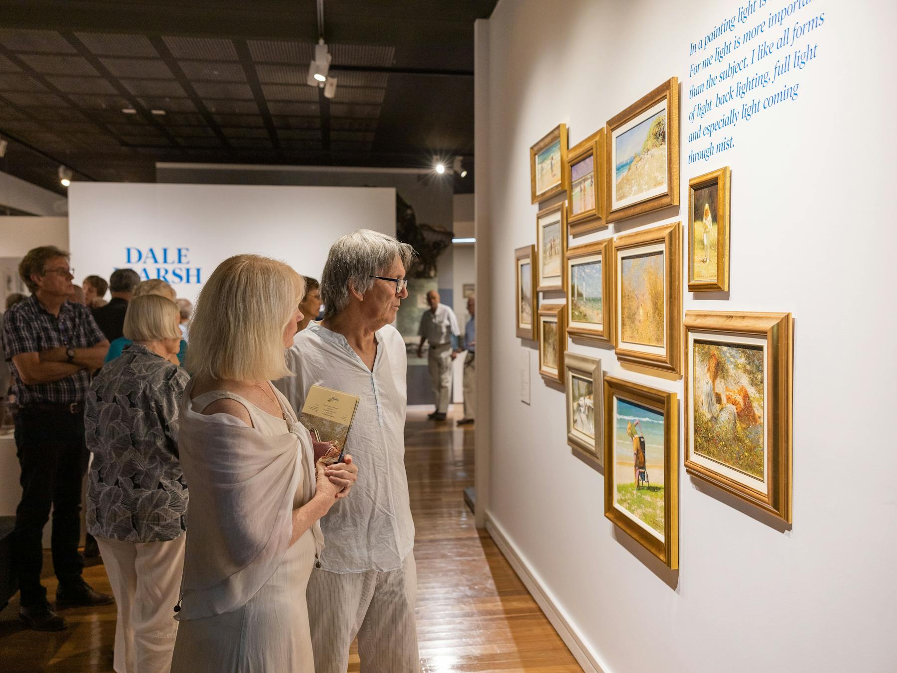 Man and woman looking at art in frames on the wall