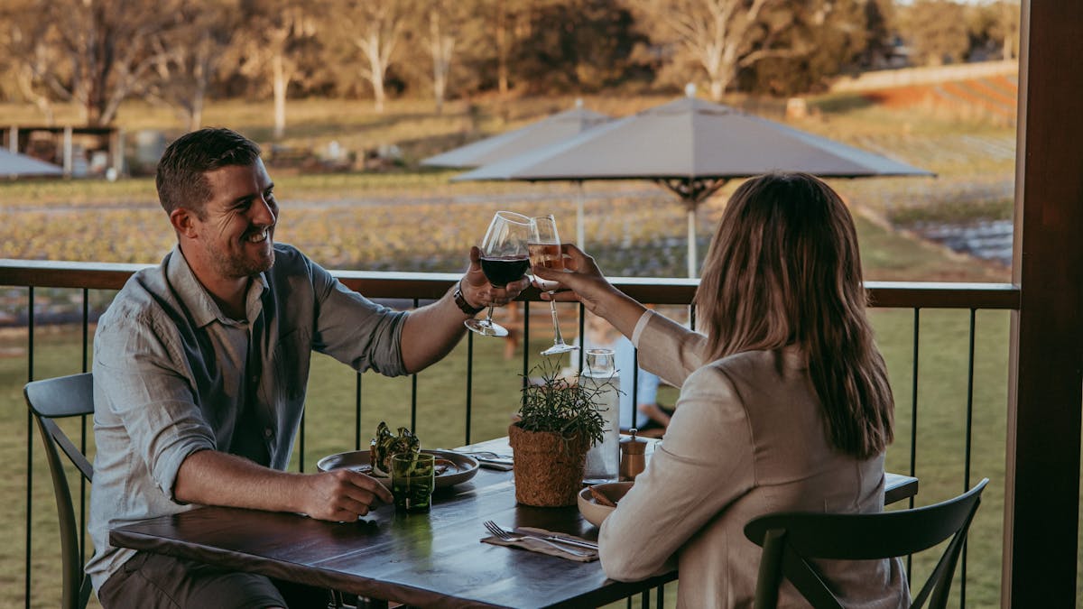 Couple saying cheers with their wine over a dinner for two