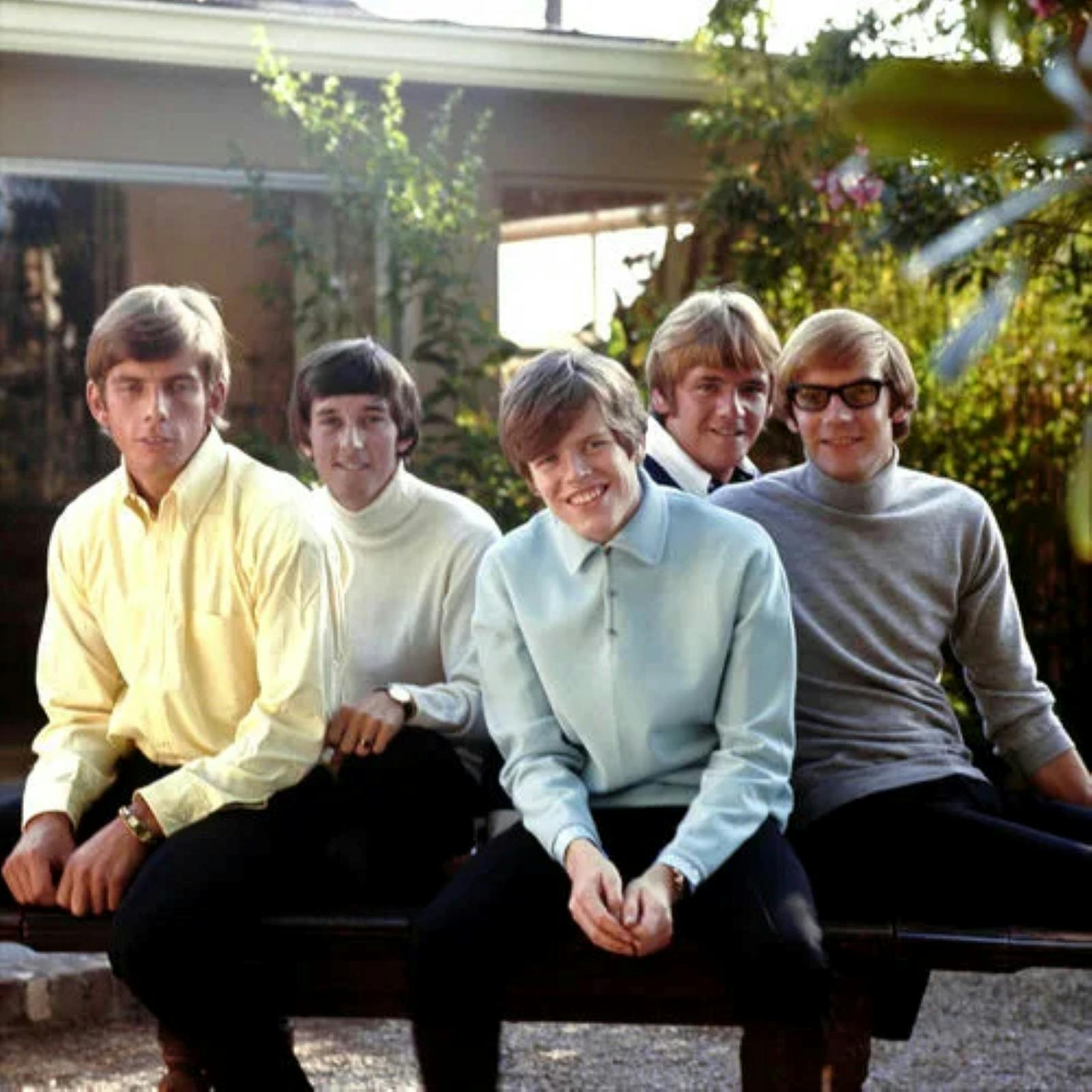 5 young men sitting on a bench.
