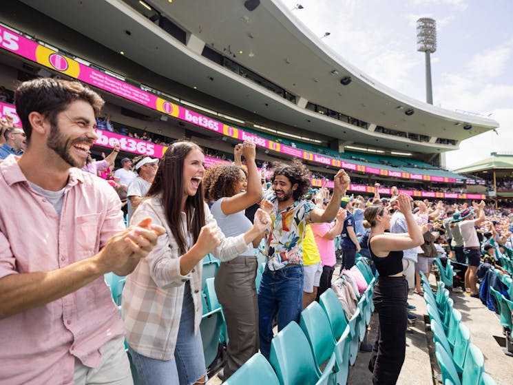 Friends cheering and enjoying a cricket game at the Sydney Cricket Ground