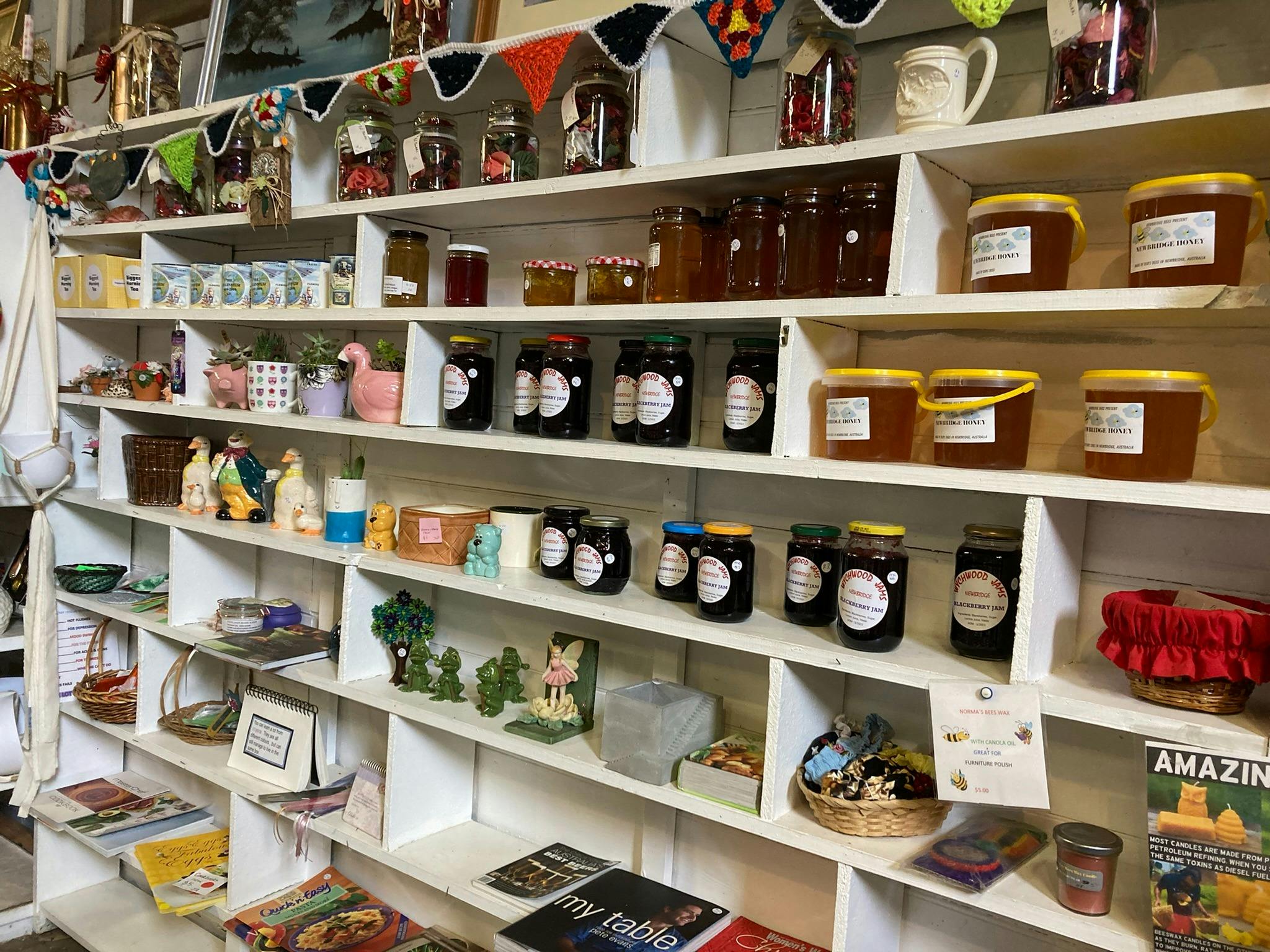 Long white shelves filled with pots of jam, honey and pickles