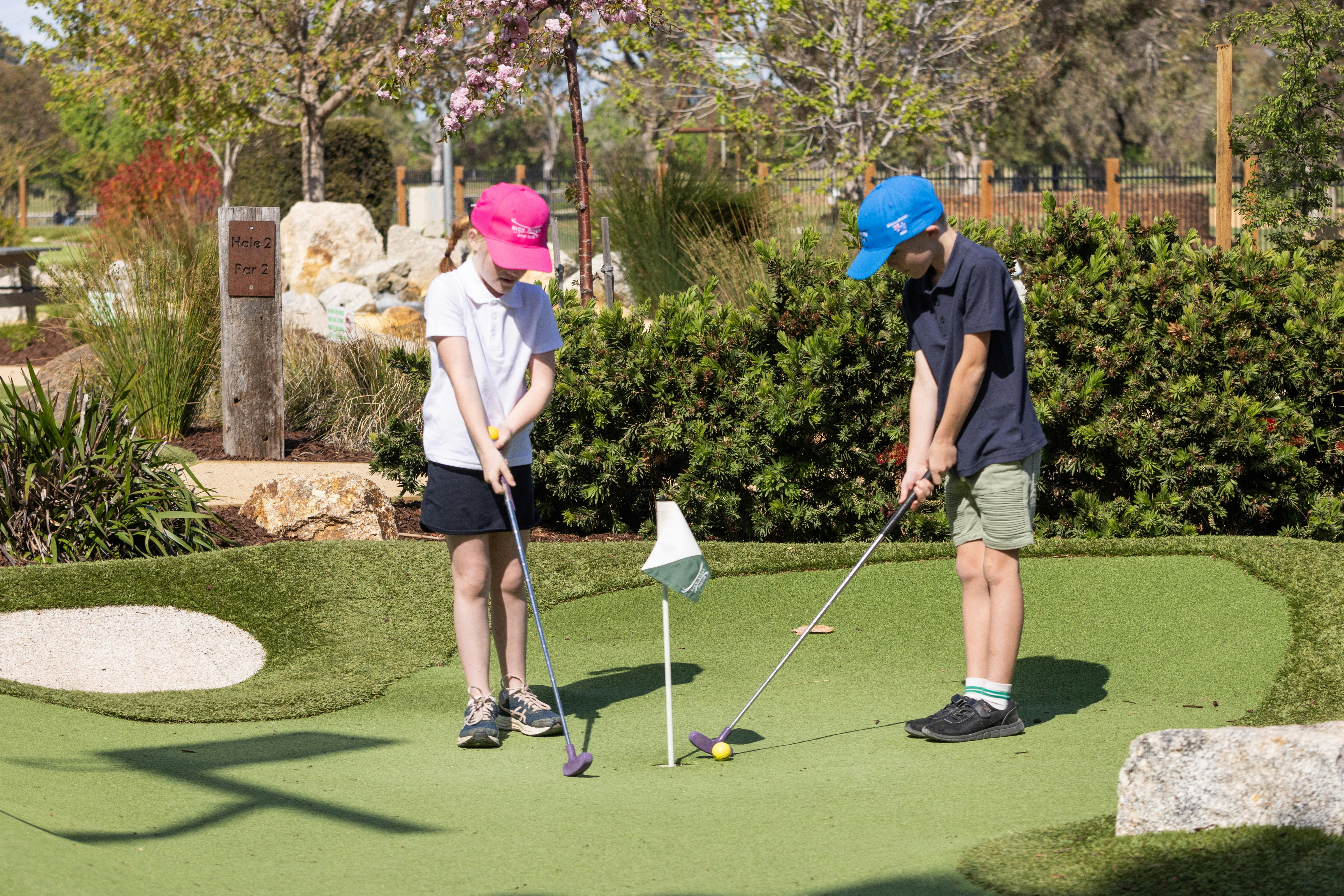 Two children playing mini golf at Rich River Golf Club